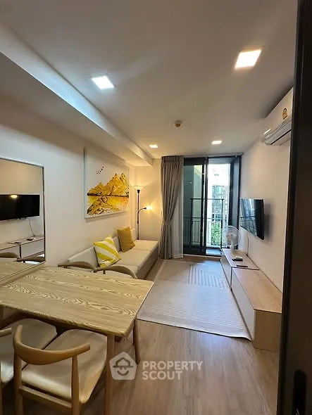 Modern living room with stylish decor and balcony view in a contemporary apartment.