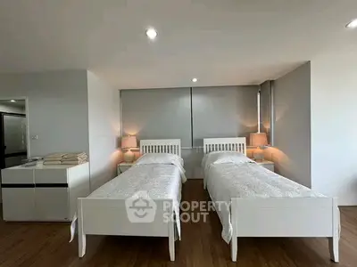 Spacious bedroom with twin beds and modern decor, perfect for comfort and relaxation.