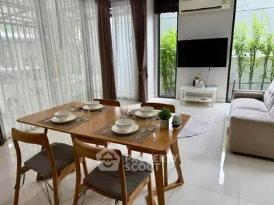Modern living room with dining area, featuring sleek furniture and large windows for natural light.