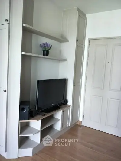 Modern living room with built-in TV cabinet and stylish wooden flooring.