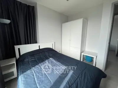 Modern bedroom with sleek white furniture and cozy bedding in a stylish apartment.