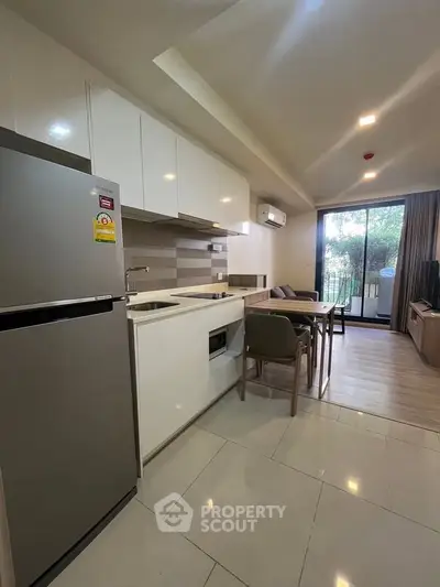 Modern kitchen with open layout and balcony view in stylish apartment.