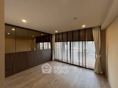 Spacious modern living room with large windows and wooden flooring