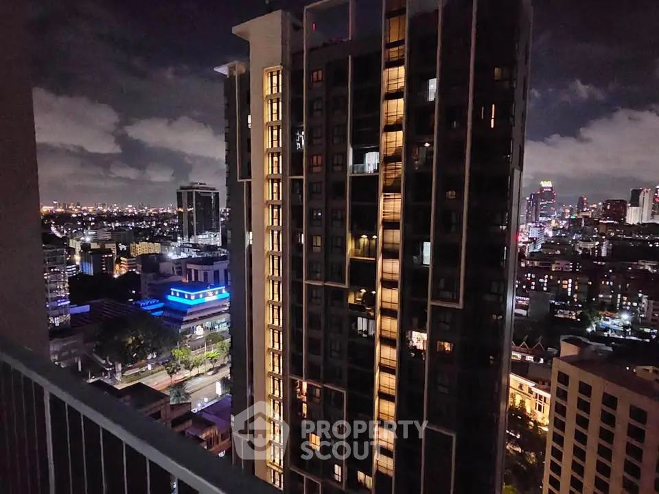 Stunning night cityscape view from high-rise balcony overlooking illuminated skyline.
