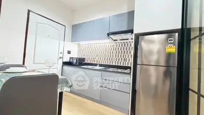 Modern kitchen with sleek cabinetry and stainless steel appliances in a stylish apartment.