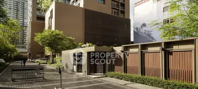 Modern urban apartment building exterior with lush greenery and secure entrance.