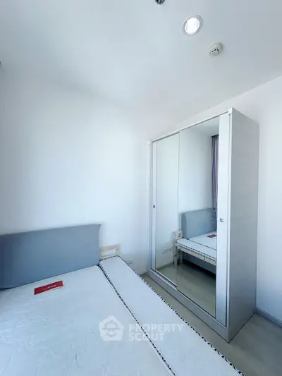 Modern bedroom with sleek mirrored wardrobe and minimalist design