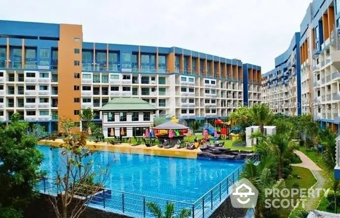 Luxurious condominium complex with large swimming pool and lush landscaping