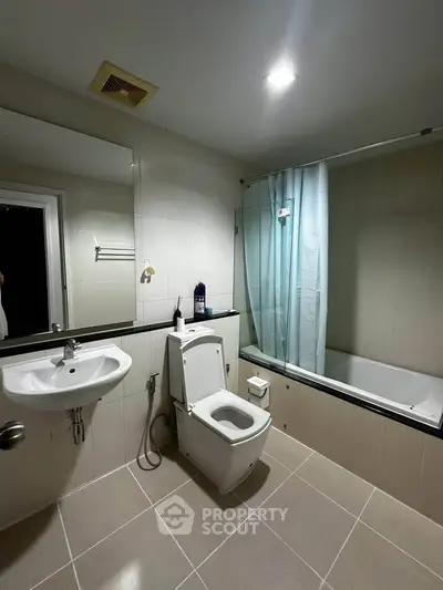 Modern bathroom with sleek fixtures and bathtub in contemporary apartment.