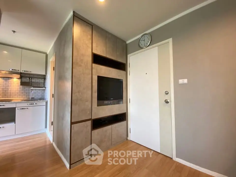 Modern apartment interior with sleek kitchen and built-in entertainment unit