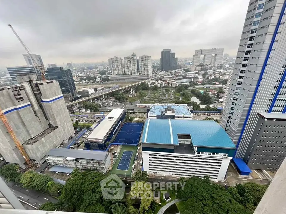 Stunning cityscape view from high-rise building with lush greenery and modern architecture.