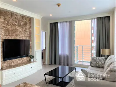 Elegant living room with polished marble wall accent, modern furnishings, and access to a sunlit balcony, perfect for upscale urban living.