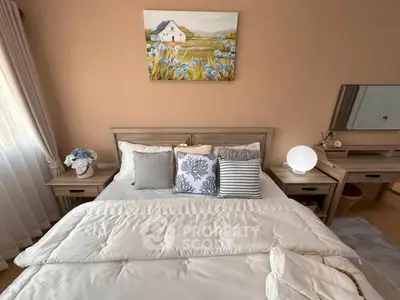 Cozy bedroom with elegant decor and natural light, featuring a stylish bed and charming artwork.