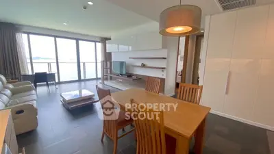 Spacious living room with ocean view, modern furniture, and elegant lighting in a luxury apartment.