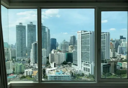 Stunning cityscape view from a high-rise apartment window, showcasing modern skyscrapers and urban skyline.