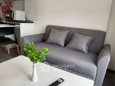 Modern living room with sleek gray sofa and stylish decor in a cozy apartment.