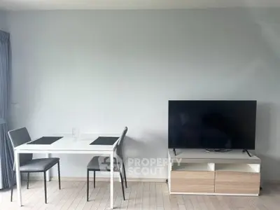 Modern living room with sleek TV stand and dining table set against a minimalist backdrop.