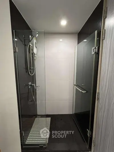 Modern bathroom with glass shower enclosure and sleek fixtures.