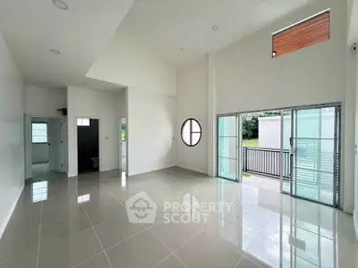 Spacious modern living room with high ceilings and large windows for natural light.