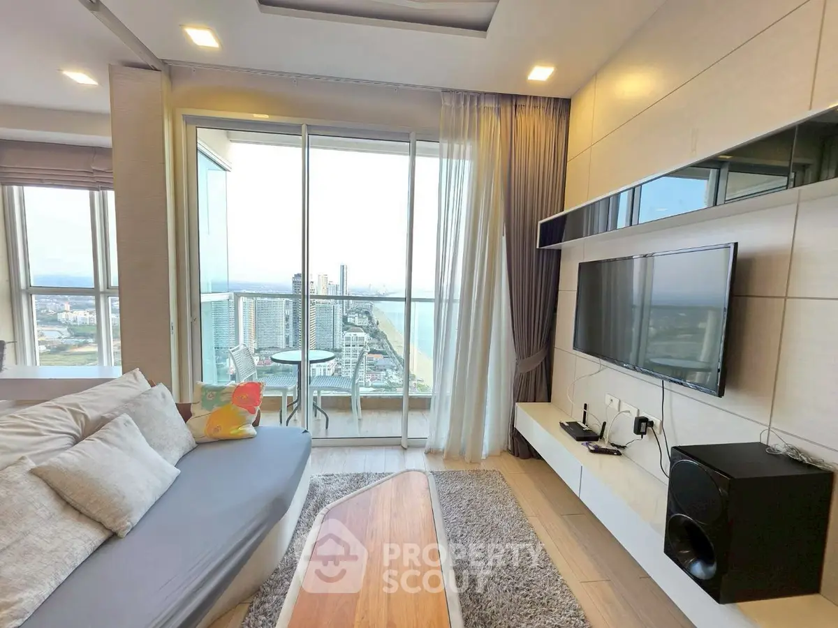 Modern living room with stunning city and ocean view, featuring sleek furniture and large windows.