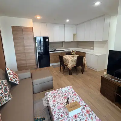 Modern open-layout living room and kitchen with stylish decor and city view.