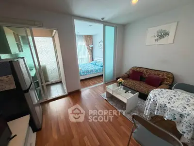 Cozy apartment with open living room and bedroom, featuring modern decor and wooden flooring.