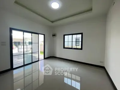 Spacious modern living room with large windows and glossy tiled floors, perfect for natural light and open living.