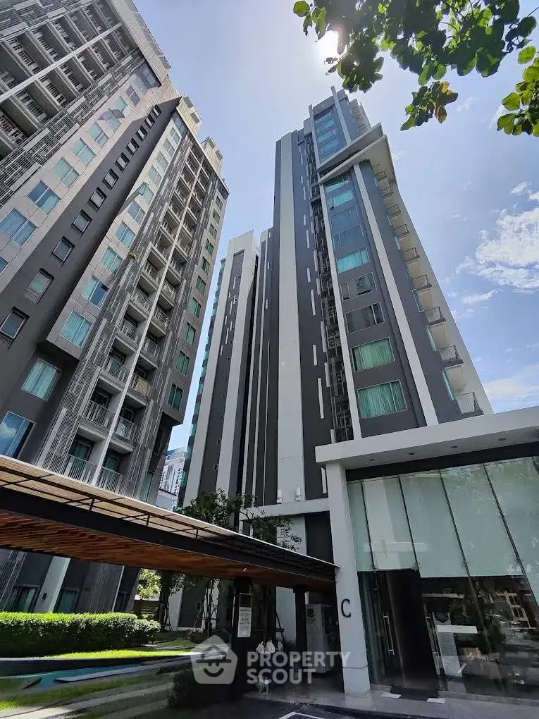 Modern high-rise residential building with sleek design and glass facade in urban setting.