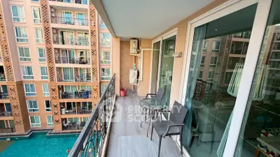 Spacious balcony with pool view in modern apartment complex