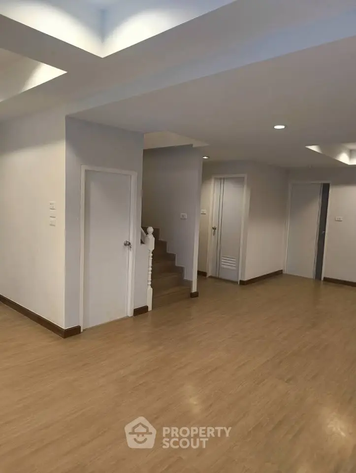 Spacious modern interior with wooden flooring and recessed lighting, ideal for versatile living arrangements.