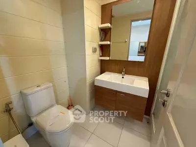 Modern bathroom with sleek vanity and large mirror in a stylish home.
