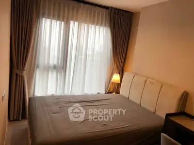 Cozy bedroom with elegant curtains and soft lighting, perfect for relaxation.