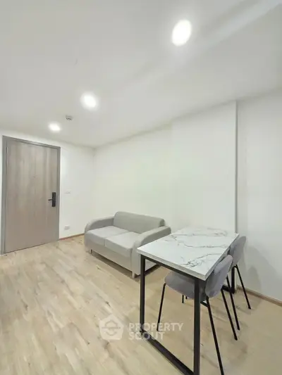 Modern minimalist living room with light wood flooring and compact furniture
