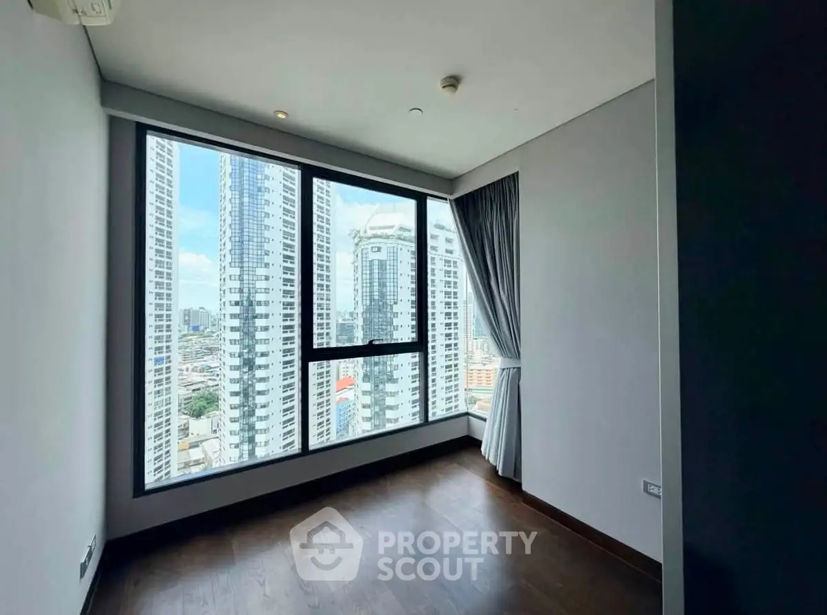 Spacious corner unit with stunning city view and large windows in modern high-rise building.