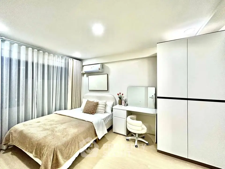 Modern bedroom with cozy bed, sleek wardrobe, and stylish vanity in bright apartment.