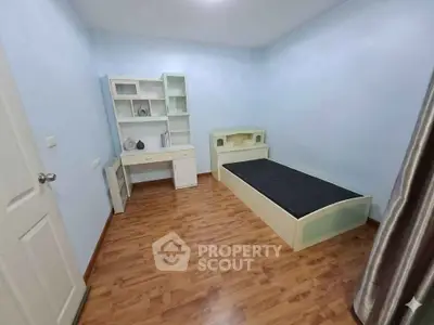 Spacious bedroom with wooden flooring and modern furniture in a minimalist design.
