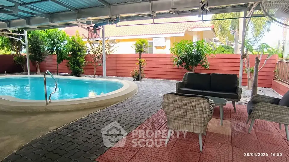 Charming outdoor pool area with cozy seating, perfect for relaxation and entertaining in a serene setting.