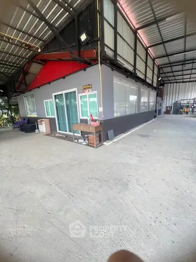 Spacious industrial warehouse with office space and ample parking area.