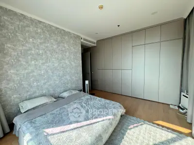 Spacious modern bedroom with stylish decor and ample natural light