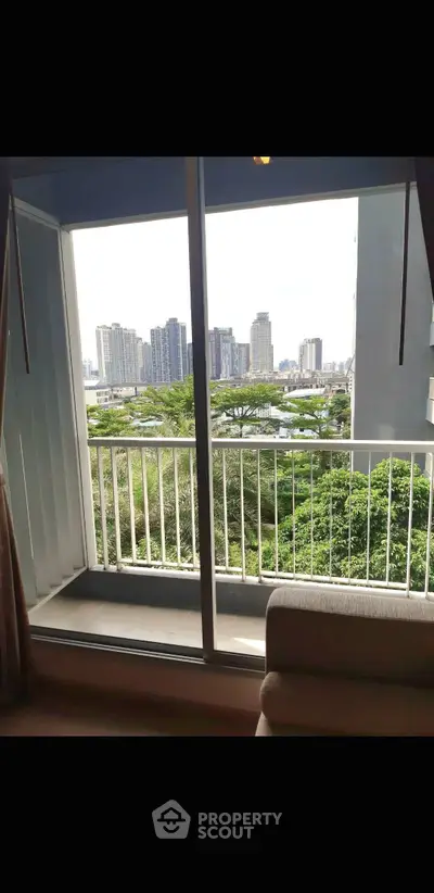 Stunning city view from a cozy balcony with lush greenery and skyline backdrop.