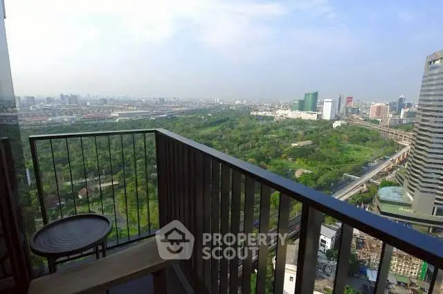 Stunning cityscape view from a high-rise balcony overlooking lush greenery and urban skyline.