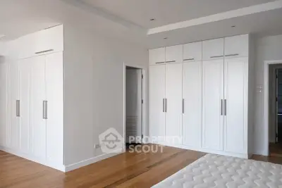 Spacious bedroom with elegant built-in wardrobes and wooden flooring