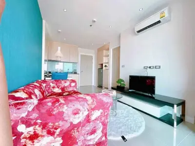 Modern living room with vibrant floral sofa and sleek TV setup in stylish apartment.