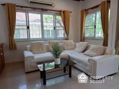 Charming living room with cozy white sofa and large windows