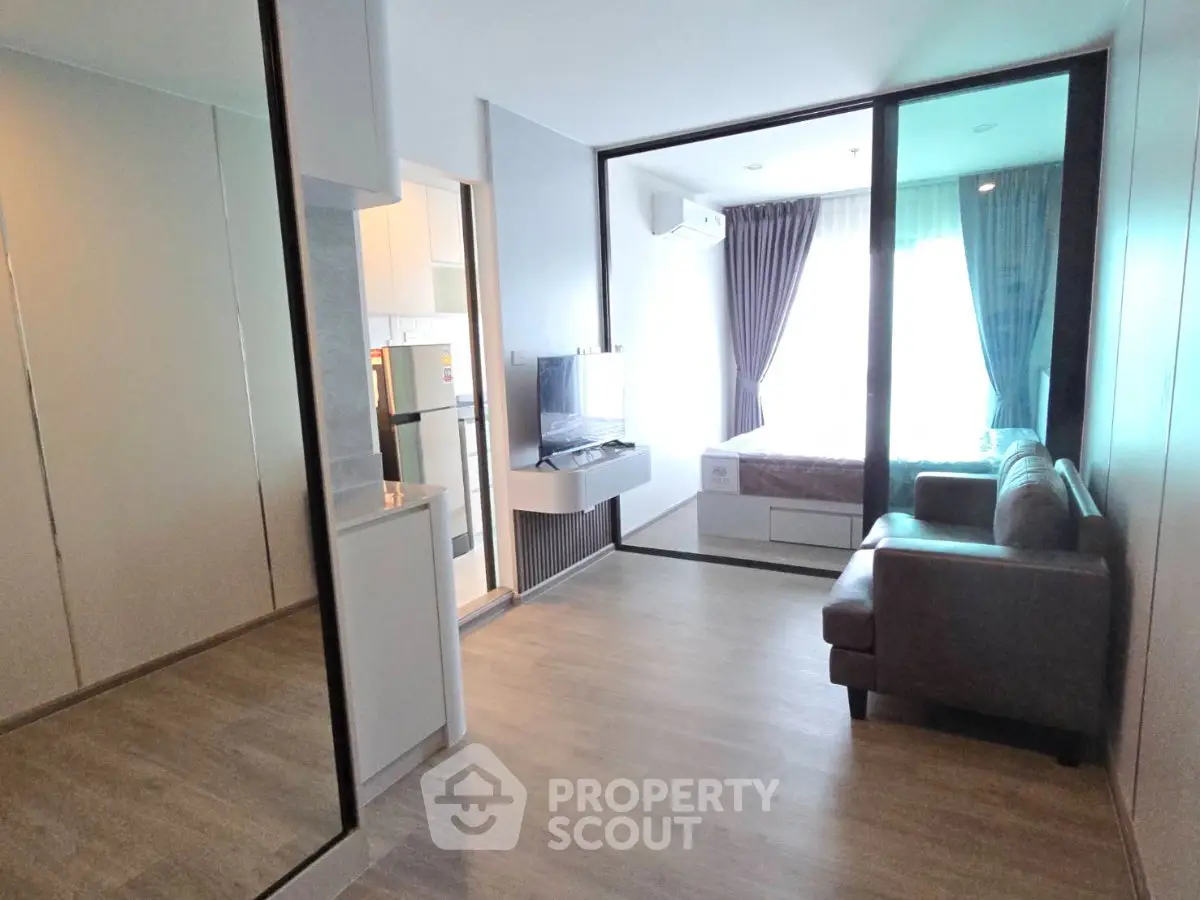 Modern apartment interior with open layout, featuring a cozy living area and sleek kitchen design.