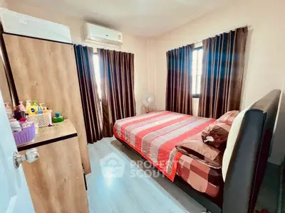 Cozy bedroom with modern decor and ample natural light, featuring stylish curtains and air conditioning.