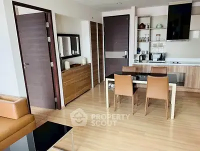 Modern open-layout kitchen and dining area with sleek furniture and wooden flooring.