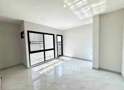 Spacious and bright living room with large windows and modern flooring
