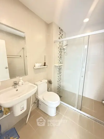 Modern bathroom with glass shower and sleek fixtures in a contemporary home.
