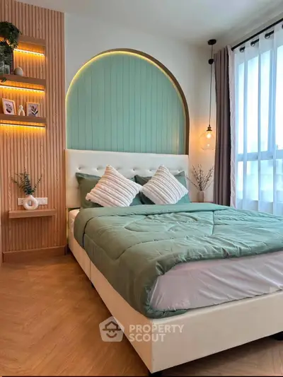 Modern bedroom with stylish decor and natural light, featuring a cozy bed and elegant lighting.